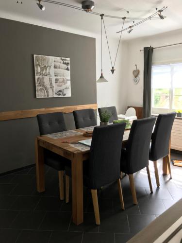 蒙绍Ferienhaus Piana的一间带木桌和椅子的用餐室