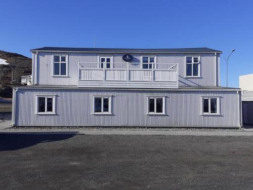 侯尔马维克Gistihús Hólmavíkur的一座白色的建筑,上面设有一个阳台