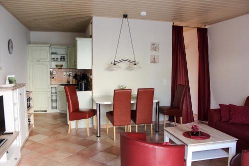 格拉尔-米里茨Ferienwohnung B4 Haus Elmsfeuer的客厅配有桌子和红色椅子
