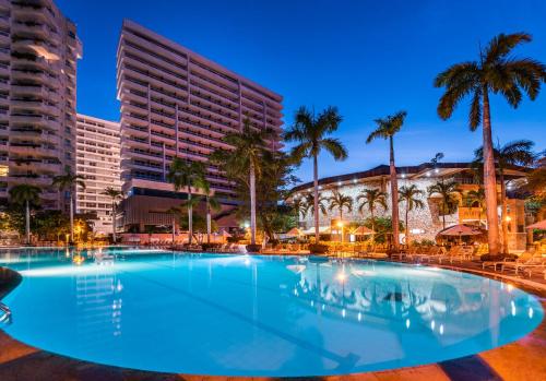 圣玛尔塔Irotama Resort的一座棕榈树和建筑的大型游泳池