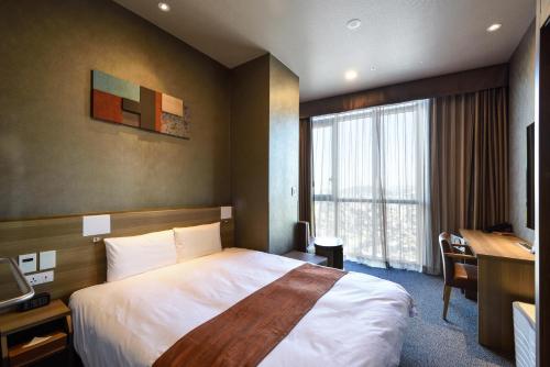 首尔多美迎首尔江南酒店的配有一张床、一张书桌和一扇窗户的酒店客房