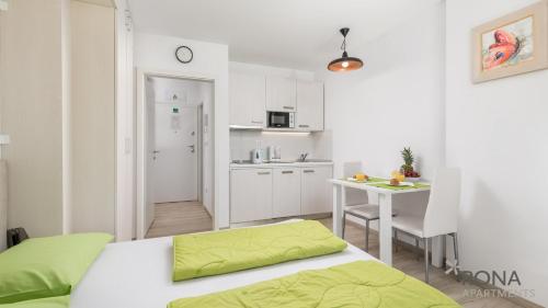 洛夫兰Rona Studio Apartment Tena的一间卧室配有一张床铺和一张桌子,还设有一间厨房