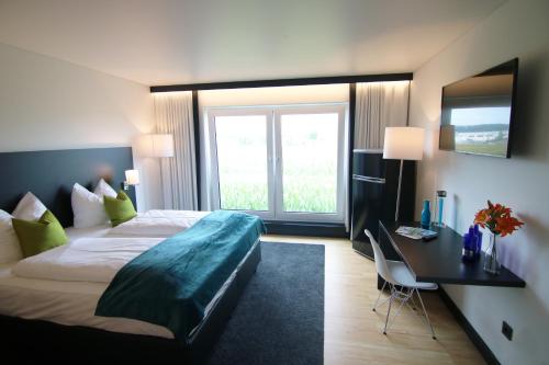 伊勒蒂森ILL Hotel by WMM Hotels的酒店客房设有一张床和一张带窗户的书桌