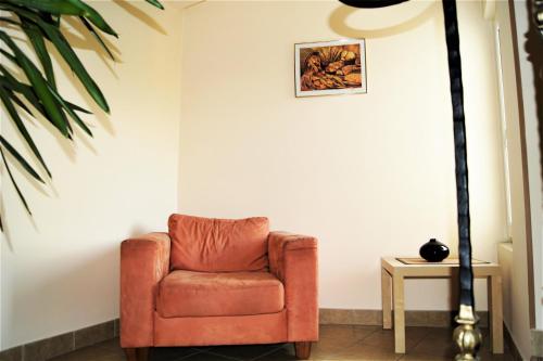 卢布林Willa Ostoja的白色墙壁的房间里摆放着橙色椅子