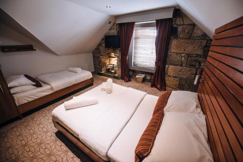 威萧商务酒店的一间卧室设有两张床和石墙