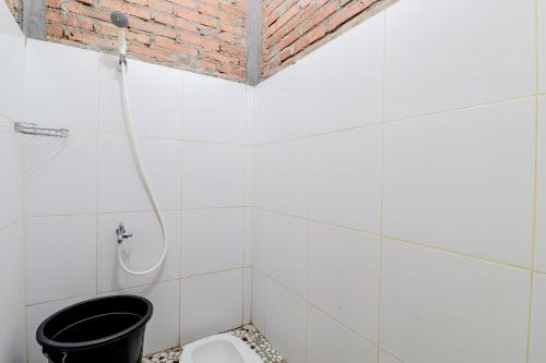 马格朗d'Hasinda Homestay的白色瓷砖浴室设有卫生间和淋浴。
