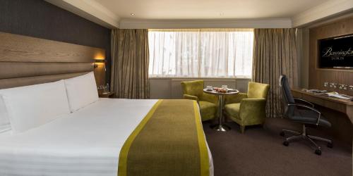 都柏林伯宁顿休闲中心酒店的酒店客房带一张床、一张桌子和椅子