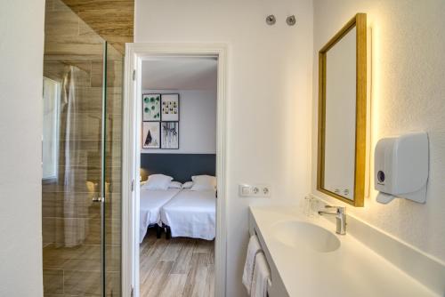 马翁岛屿旅馆的浴室设有床、水槽和镜子