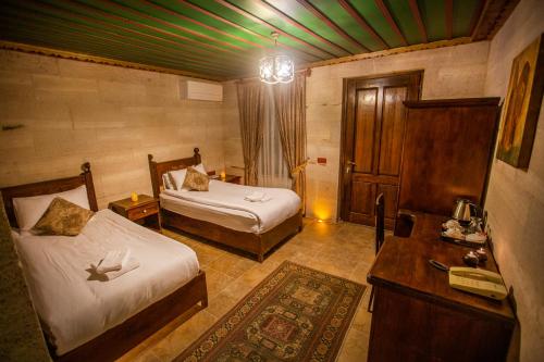 乌奇希萨尔赫尔墨斯窑洞酒店的一间设有两张床的卧室,位于一个绿色天花板的房间