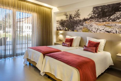 法蒂玛Serra d'Aire Boutique Hotel - SA Hotels的配有大窗户的酒店客房内的两张床