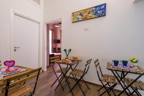 萨莱诺B&B PETER PAN的客厅配有2张桌子和椅子,墙上挂有绘画作品