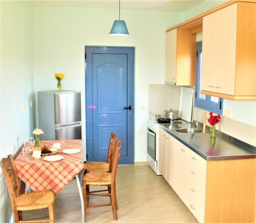 RomanuStamna Farm的厨房配有桌子和蓝色的门
