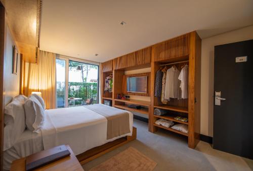 坎布里Hotel Spa Nau Royal的一间卧室设有一张床、一台电视和一个窗口。