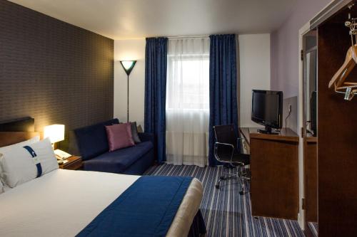 伦敦快捷假日皇家码头酒店酒店的酒店客房,配有床和沙发