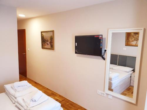 布德瓦Apartments Pier的一间设有镜子和墙上电视的房间