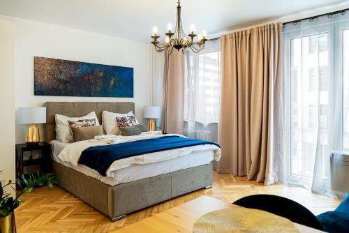 弗罗茨瓦夫Apartament Oławska的一间卧室配有一张大床和一个吊灯。