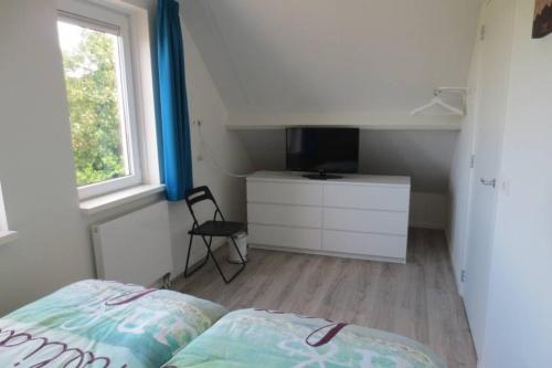 佐特兰德Luxe vakantiewoning dicht bij strand的一间卧室配有一张床、一个梳妆台和一扇窗户。
