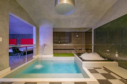 福塔莱萨Spa urbano Motel Adult Only的一间带大型游泳池及浴缸的浴室