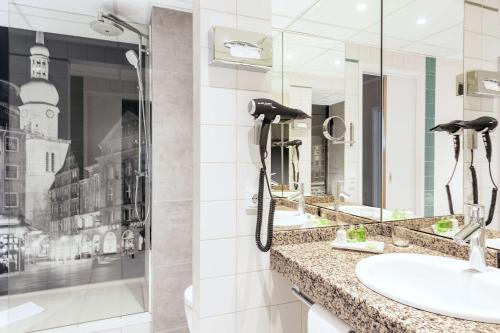 多特蒙德NH多特蒙德酒店的一间带两个盥洗盆的浴室和墙上的一部电话