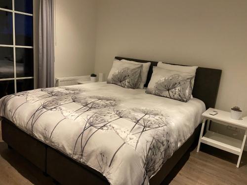 达尔夫森Hof van Lenthe appartement De Mars的卧室配有带白色棉被的床
