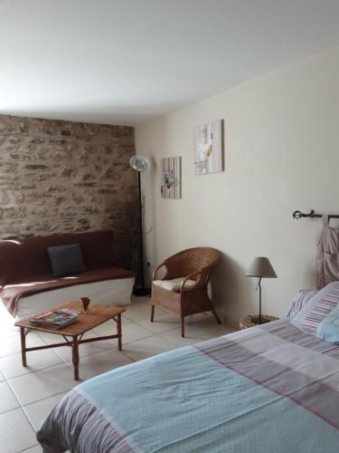 赛拉古斯Mas Rondole - Chambres d'hôtes的一间卧室配有一张床、一张沙发和一张桌子