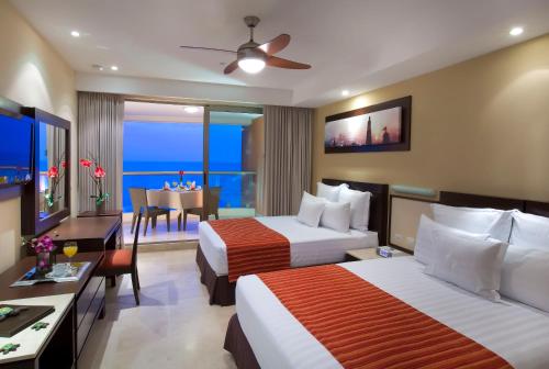 巴亚尔塔港Sunset Plaza Beach Resort Puerto Vallarta All Inclusive的一间酒店客房,设有两张床和一间餐厅