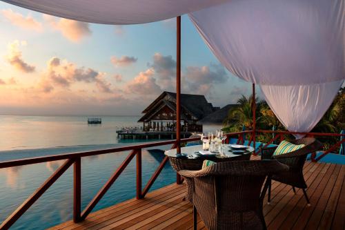 南马累环礁Anantara Dhigu Maldives Resort - Special Offer On Transfer Rates For Summer 2024的一个带桌椅的海景阳台。