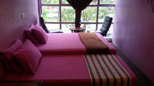 阿罗士打Hijrah Hotel的一间卧室设有两张床和大窗户