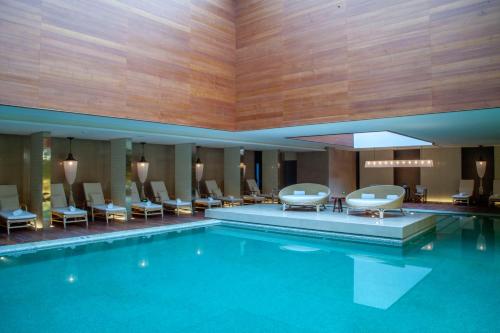 成都成都群光君悦酒店的一座配有桌椅的酒店游泳池