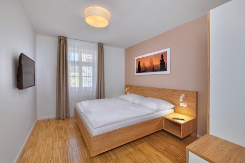 布拉格卡丹斯克市中心套房酒店的一间小卧室,配有床和窗户