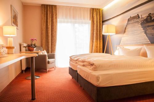勒伯尔米利茨海滨酒店的配有一张床、一张书桌和一扇窗户的酒店客房
