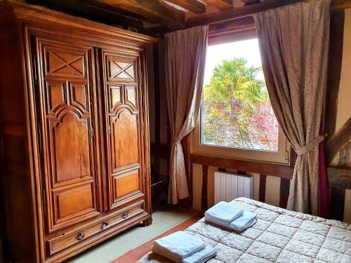 翁弗勒尔La Venelle Saint Jean的一间卧室配有梳妆台、一张床和一个窗户。
