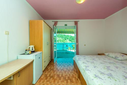 波拉斯Guest House Radulj的一间卧室设有一张床,并有通往阳台的门