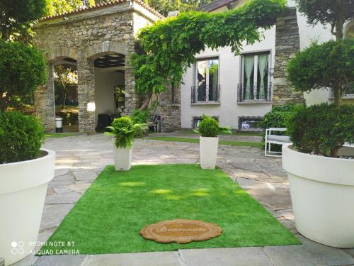 Buguggiate"La Selvetta" bed and breakfast的一座花园,房子前面有一片圆形的草地