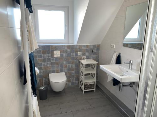 索尔陶Heidewohnung的一间带水槽和卫生间的浴室以及窗户。