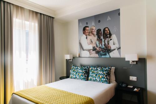 里斯本America Diamonds Hotel的酒店客房的墙上设有一张带四柱床的床铺。
