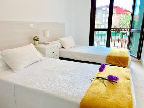 诺哈Apartamento El Socaire Playa Trengandín的一间卧室配有两张带黄白色床单的床