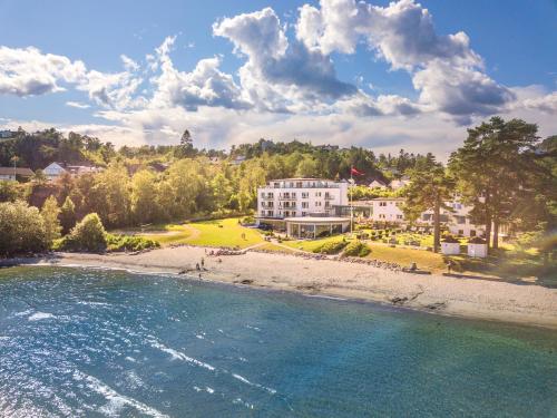 弗维克Strand Hotel Fevik - by Classic Norway Hotels的白色房屋享有海滩的空中景致