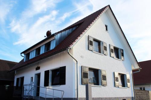 莱茵豪森Ferienwohnung Susi's Daheim bei Europa Park Rust的白色房子,有棕色的屋顶