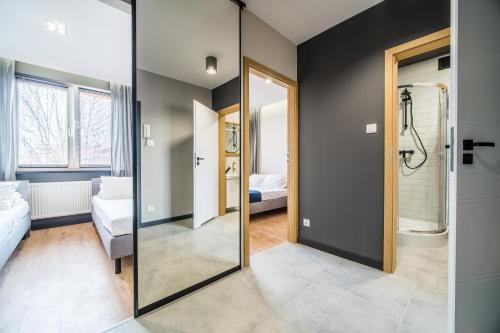 比亚韦斯托克Rint - Centrum Zamenhofa Street的浴室设有玻璃门,可通往卧室