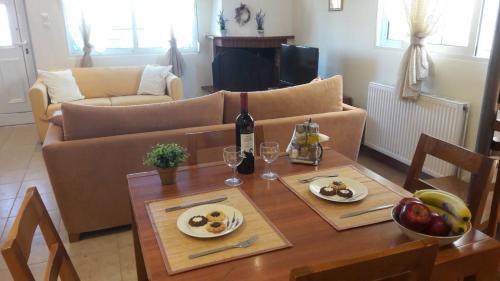 尼亚普拉莫斯Ideal Family House的客厅配有带食物和一瓶葡萄酒的桌子