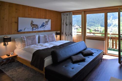 格林德尔瓦尔德卡巴那酒店的一间卧室配有一张床、一张沙发和一个窗口