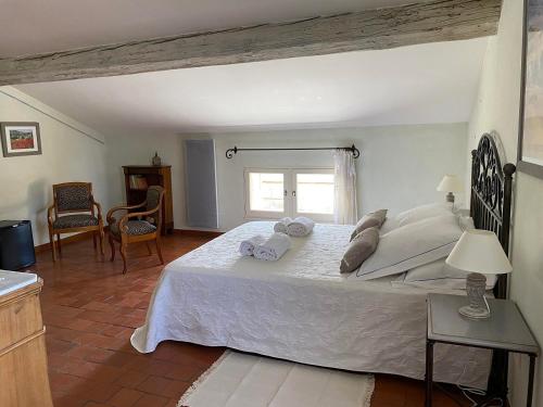 勒托尔Le Mas de la Martelière的卧室配有带毛巾的大型白色床