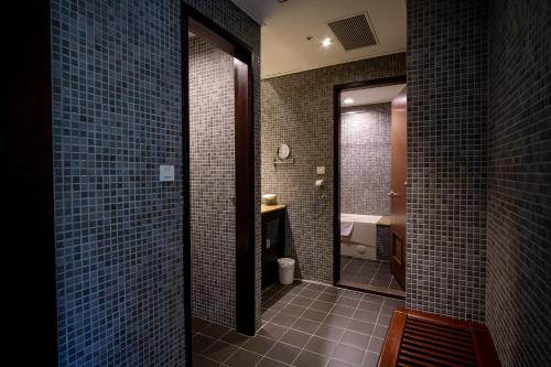 柳营柳營尖山埤 Liuying Jianshanpi Resort的浴室设有蓝色瓷砖墙壁和镜子