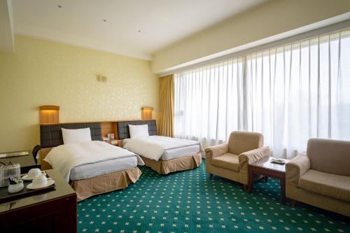 柳营柳營尖山埤 Liuying Jianshanpi Resort的酒店客房,配有两张床和两把椅子