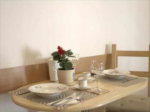 布拉索夫Anna Apartment的木桌,带盘子和玻璃杯,桌布