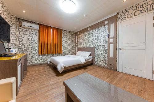 扶余苏乌汽车旅馆的一间卧室配有一张床、一台电视和一扇门