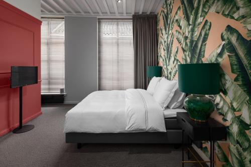 米德尔堡Boutique Hotel De Vier Patriciërs的卧室配有白色的床和色彩缤纷的墙壁