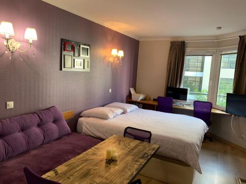 伊西莱穆利诺ALTAMIRA (Paris Expo - Porte de Versailles)的酒店客房,设有两张床和一张沙发