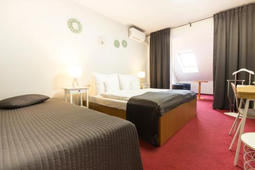 米库洛夫米库洛夫莫洛里酒店的酒店客房带两张床和一张桌子以及椅子。